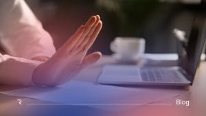 holding hand up in a stop or enough position. sitting in front of a laptop
